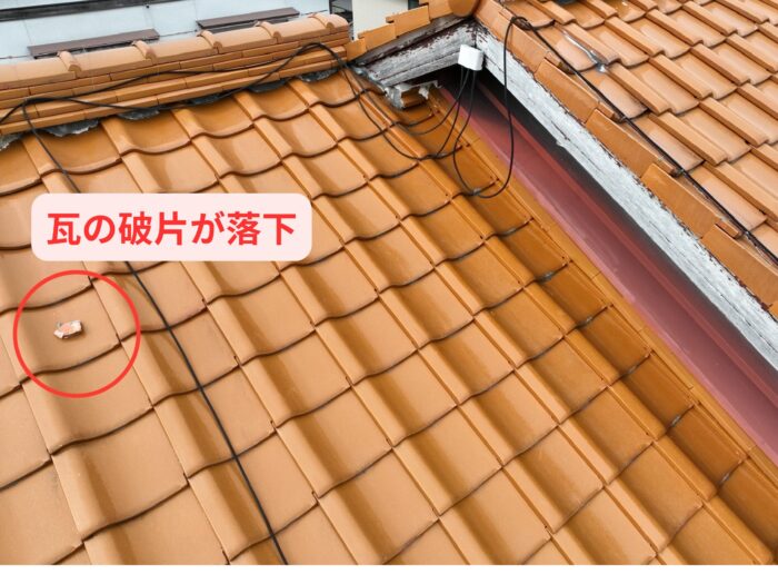 屋根上の瓦に小さな破片が乗っており、周囲の瓦にズレが見られる。