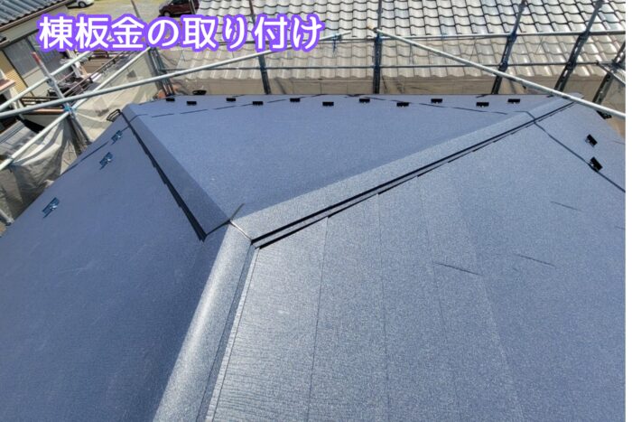 屋根上で棟板金を固定している