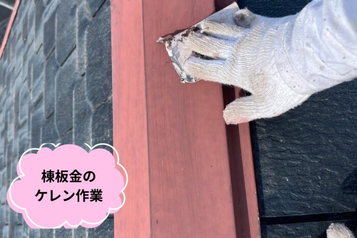 棟板金の赤い下地をケレン作業で磨き、サビや古い塗膜を落としている写真