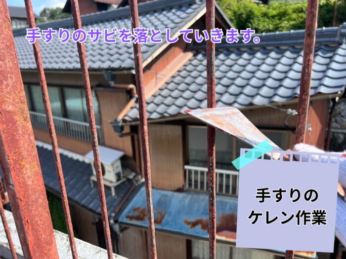 鉄製手すりの錆をケレンヘラで削り落としている様子