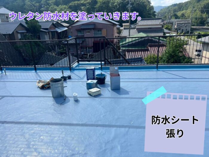 ベランダ全面に青い防水シートを敷き、塗装準備を進めている様子