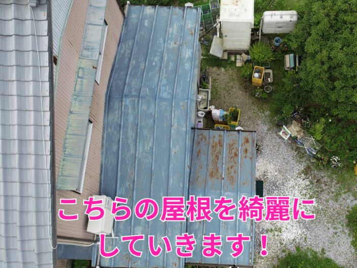 色あせと赤サビが点在する金属屋根を上空から撮影した写真。