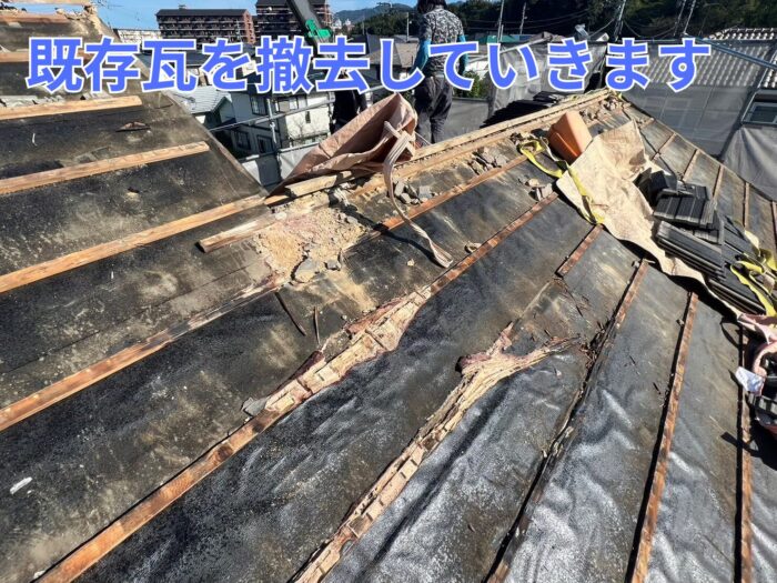 既存瓦を外し終え、腐食した野地板が露出している作業中の写真。