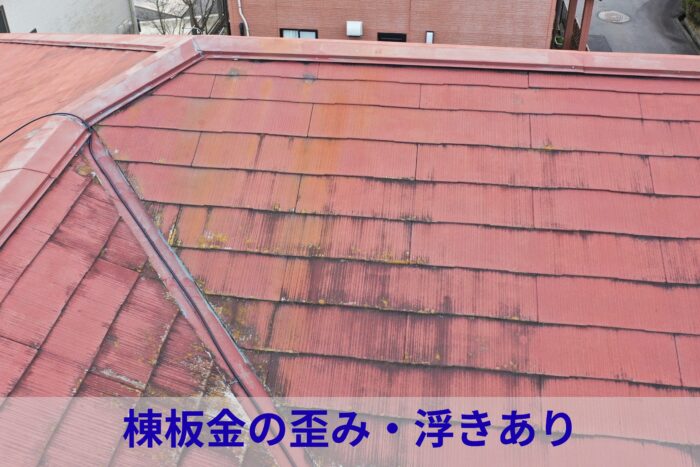 棟板金周辺がわずかに変形し、屋根材に色あせと苔が見られる状態の写真