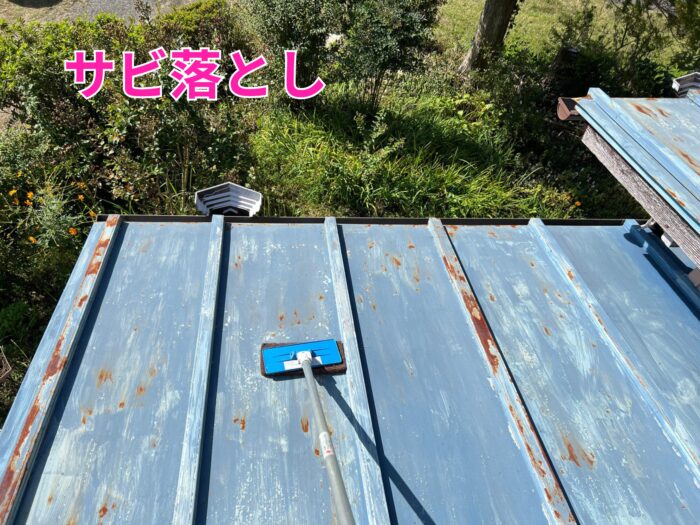 赤サビが出た金属屋根をケレンパッドで磨いている様子。