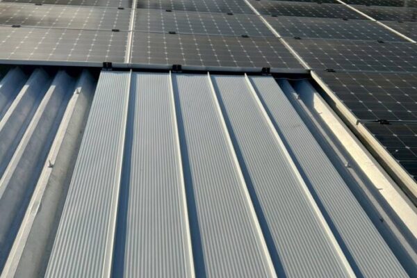 太陽光パネルが設置された折板屋根と、トップライト撤去後に新しく施工された金属屋根部分の様子。