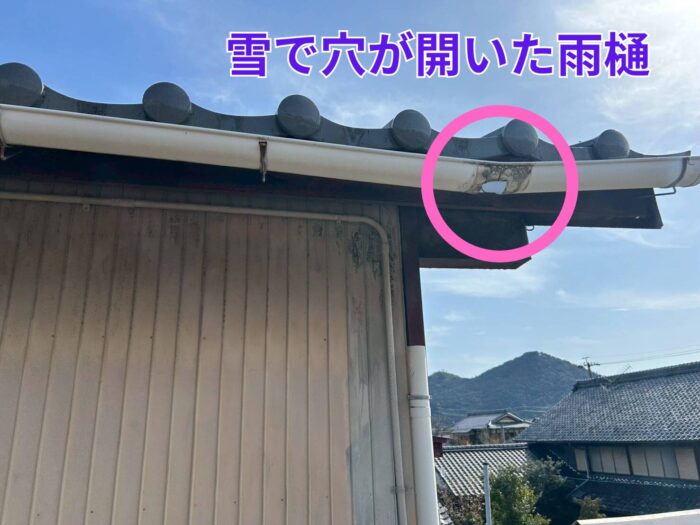 雪の重みで穴が開き変形してしまった軒樋の様子