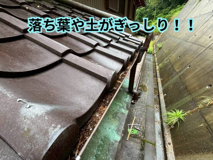 落ち葉や土が溜まった瓦屋根の雨樋内部の様子