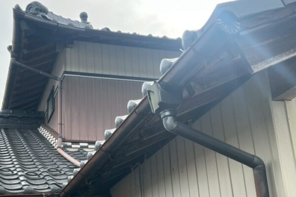八百津町で行った雨樋交換工事後の写真。和瓦屋根に新しい雨樋と集水器が取り付けられている。