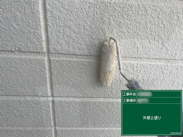 外壁塗装の上塗りを行い、美しく仕上げている様子