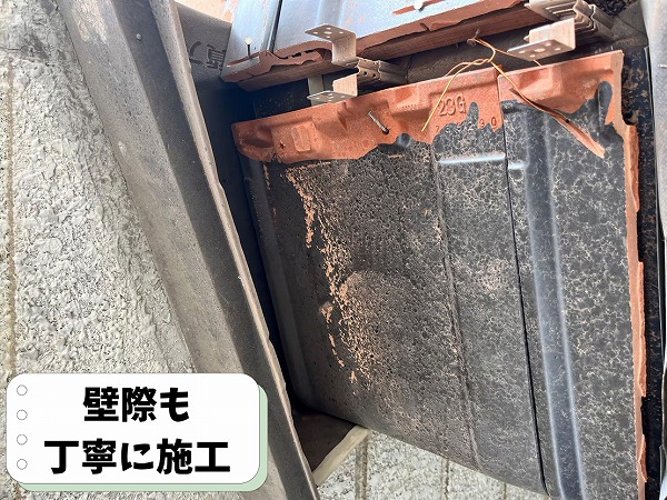 屋根と外壁の取り合い部分(壁際)の瓦を丁寧に施工している様子