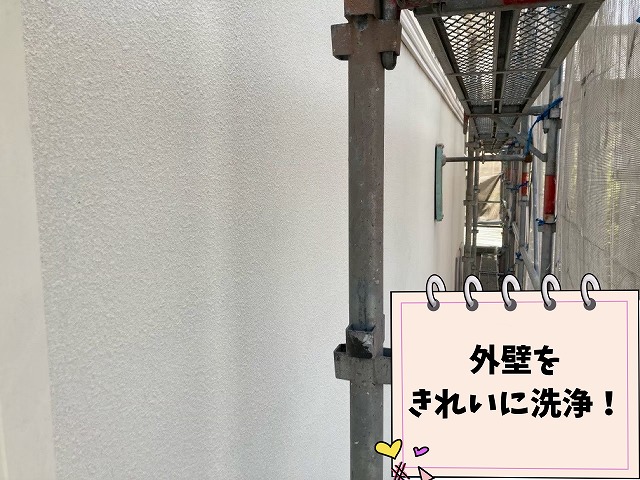 足場の設置された建物の外壁を水洗いしている様子