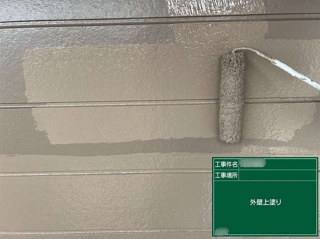 可児市中恵土で外壁の上塗りを行い、美しく仕上げている施工中の様子
