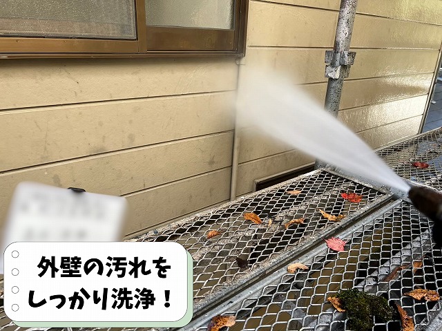 可児市中恵土で外壁塗装前に高圧洗浄を行い、外壁の汚れやコケを洗い流している様子