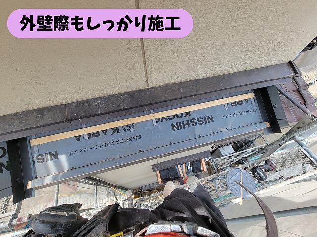 春日井市高蔵寺の屋根葺き替え工事で外壁際の防水処理を施工する様子
