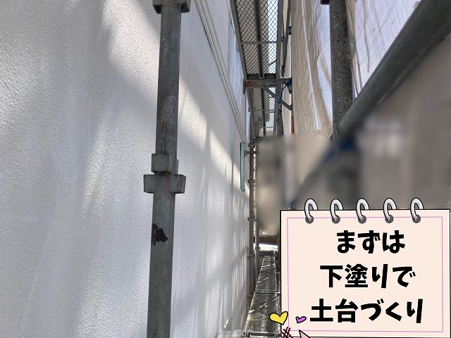 外壁に下塗りを施工している様子