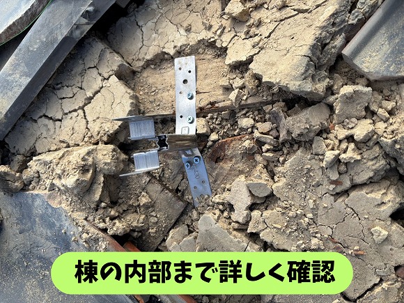 春日井市坂下町の瓦屋根で棟内部の古い土と固定金具を確認している様子