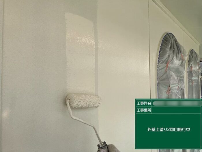 春日井市石尾台の住宅で外壁の上塗り2回目を施工している様子