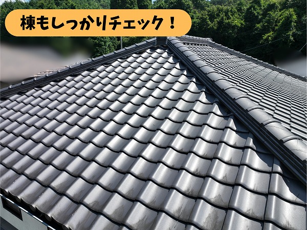 瓦屋根の棟部分を近くから撮影した写真。屋根と屋根が交わる棟の状態を確認している様子。