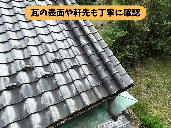 瓦の表面や軒先の雨どいの状態を確認している様子