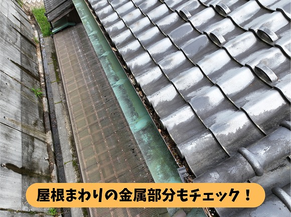 瓦屋根の軒先にある緑色に変色した金属部分と雨どいの様子